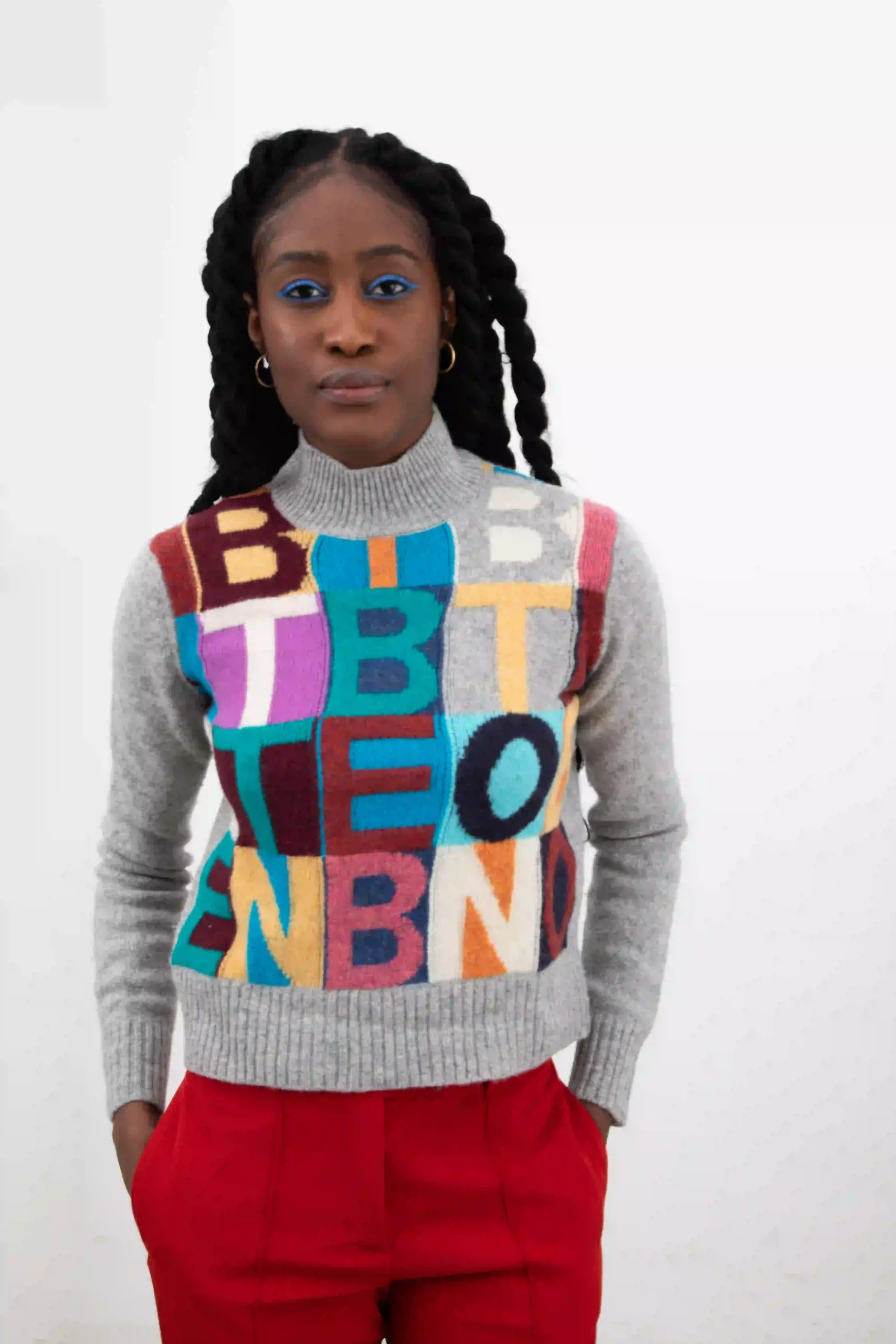 Benetton turtleneck sweater clearly inspired by the embroidered artwork of Alighiero Boetti. Multicolor letters, on a gray mélange wool base.