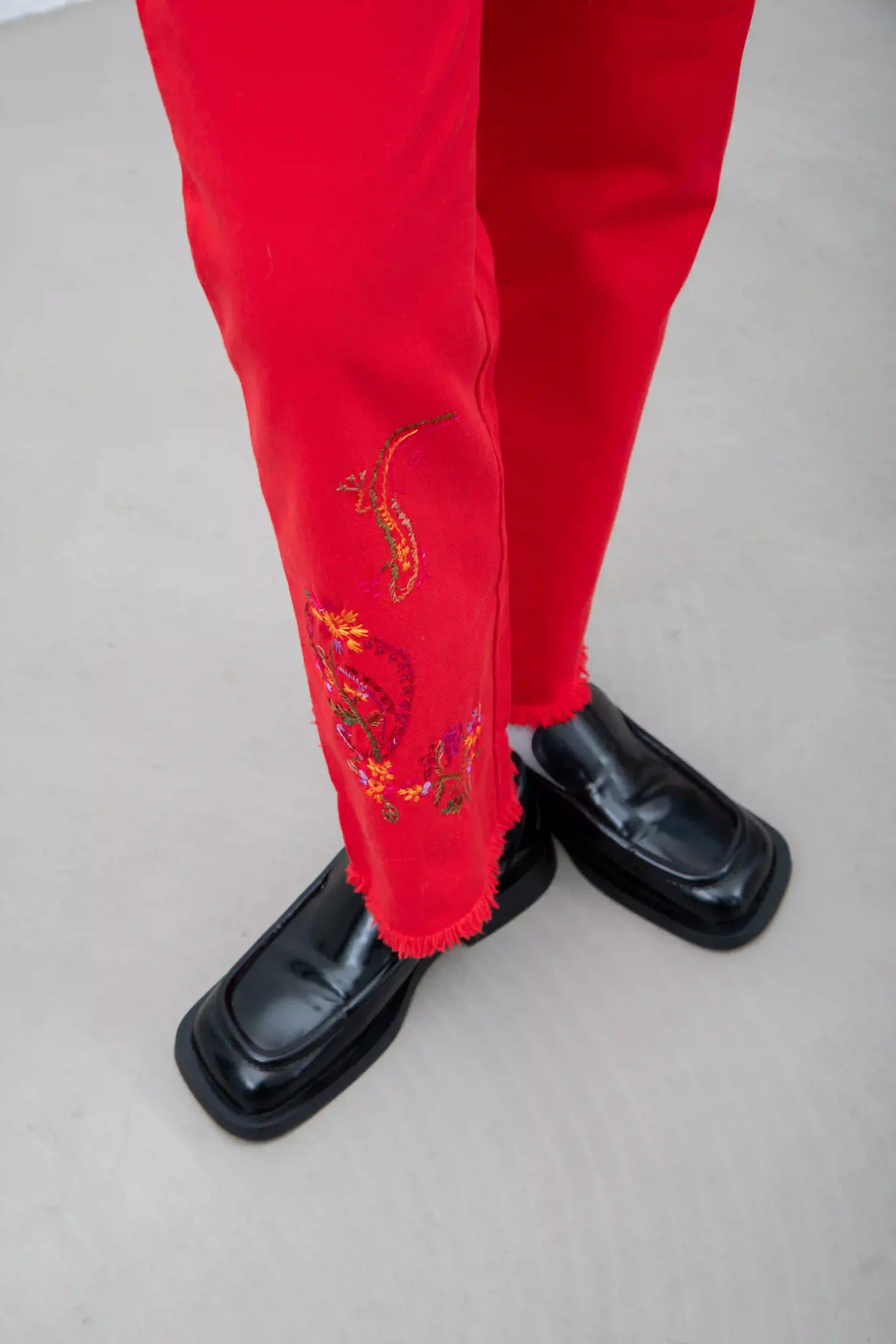 Pantalone Stefanel in drill di 100% cotone, rosso, con bordi e vita sfrangiati. Ricamo in stile anni ’70 sulla gamba destra (indossata), motivo a fiori e paisley.